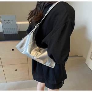 Detail showing the pleated silver texture and adjustable strap of the metallic hobo bag