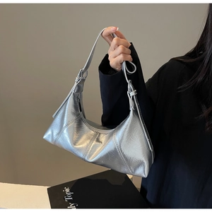 Detail of silver metallic hobo bag featuring glossy waxed leather texture and metal buckle
