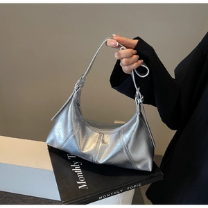 Detail of silver metallic hobo bag featuring fashionable pleated PU leather and zipper