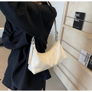 Detail of white vintage oil wax leather crossbody bag with stitching and silver buckles