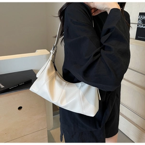 Detailed side view of off-white crescent underarm bag with decorative radial stitching