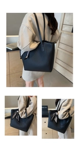 Detailed macro view of black pebbled leather tote bag featuring a chic silk scarf accent