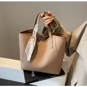 Detail of light brown lychee grain leather tote bag with decorative printed silk scarf