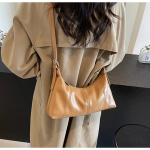 Detail of vintage caramel oil-wax leather shoulder bag with pleated texture and adjustable strap