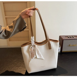 Detail of white lychee grain tote bag with brown handles and elegant geometric silk scarf