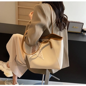 Detail of white lychee leather tote bag with brown handles and decorative silk scarf