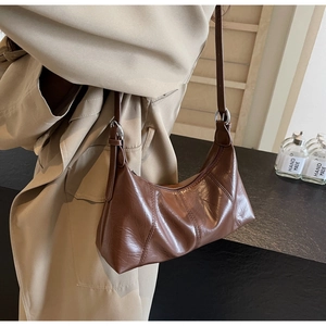 Close-up of vintage brown oil wax leather hobo bag with adjustable silver metal buckle
