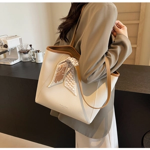 Detail of white lychee leather tote bag with brown straps and stylish silk scarf detail
