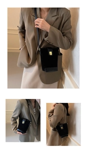 Detail of black matte suede bucket bag with gold square buckle and vintage hardware