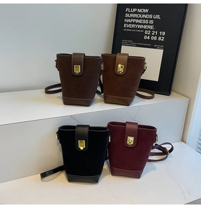 Detailed close-up of retro suede bucket bags in brown, black, and wine red with gold buckles