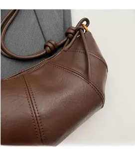 Détails du sac croissant matelassé marron foncé avec bandoulière en cuir noué élégant