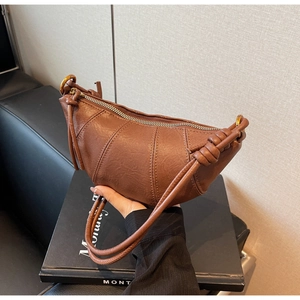 Gros plan détaillé du sac croissant marron avec poignée nouée et texture de cuir surpiqué