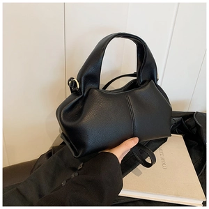 Close-up of black lychee grain faux leather cloud bag with elegant gold metal hardware