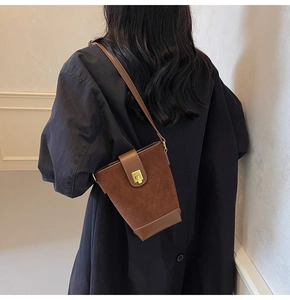 Detailed back view of vintage brown bucket bag in suede and smooth leather on black coat