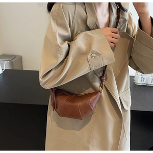 Vue détaillée du sac croissant marron caramel avec texture grainée et nœud sur l'anse