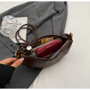 Détail de l'intérieur du sac croissant marron montrant l'espace pour téléphone et portefeuille