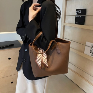 Brown litchi grain leather tote bag with decorative silk scarf and adjustable strap