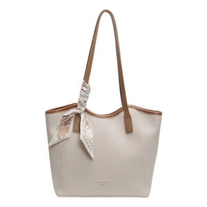 Minimalist beige pebble leather tote bag with brown straps and silk scarf accent