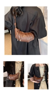 Detail view of brown croissant shoulder bag featuring unique knotted strap and patchwork leather