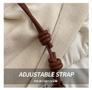 Detail view of the dark brown leather adjustable knotted shoulder strap on a crossbody bag