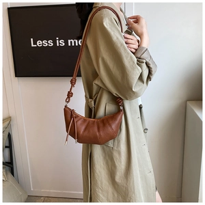 Detail of vintage brown crescent bag with leather pleats and stylish knot shoulder strap