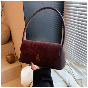 Close-up of retro mahogany baguette bag featuring suede texture and bronze metal buckle