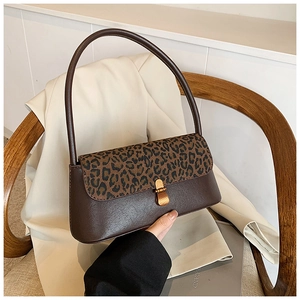 Détail du rabat élégant à motif léopard et du loquet doré sur un sac à main marron