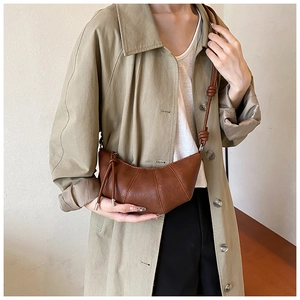 Brown faux leather croissant bag with stitched details and a knotted shoulder strap