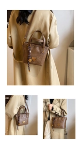 Detail of vintage brown tote bag with woven bell charm and triangle metal logo