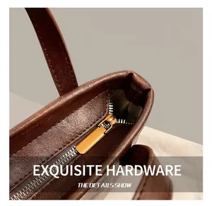 Detailed close-up of premium brown leather texture and golden metal zipper hardware