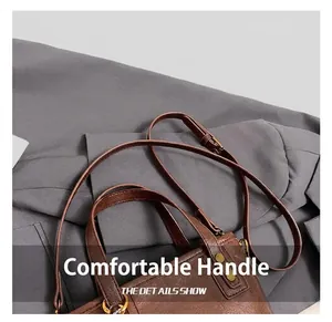 Detail showing the retro oil wax leather texture and golden metal hardware of the brown bag