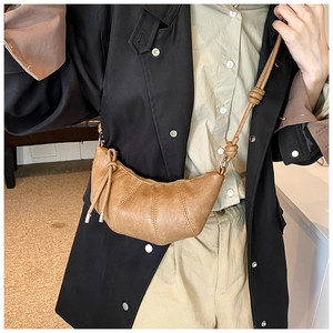 Close-up of vintage brown croissant bag showing soft pleated texture and knot shoulder strap