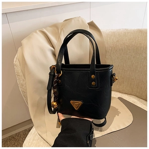 Detail of black leather bucket bag with gold triangle logo and stud decorations
