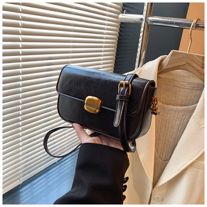Detail of vintage black crossbody bag with pleated oil wax leather and gold metal clasp