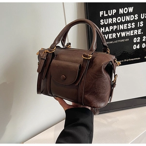 Close-up of vintage brown shoulder bag showing oil wax leather texture and front pocket