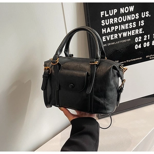 Close-up of black retro boston bag showing leather texture and gold hardware details