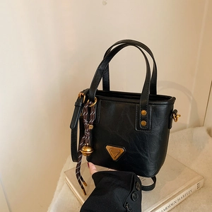 Fashionable black bucket handbag with golden triangle logo and woven bell charm