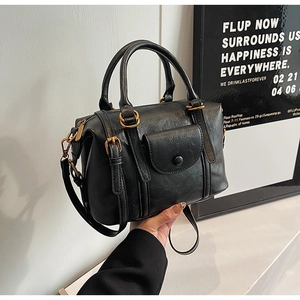 Detail of black vintage crossbody bag with gold hardware and wrinkled faux leather texture