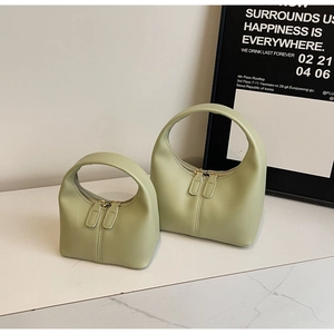 Detailed view of two matcha green hobo bags in different sizes on marble surface