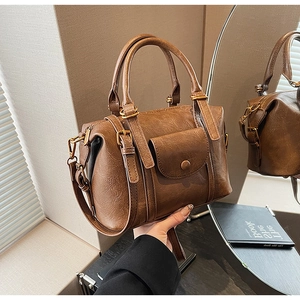 Detailed macro view of vintage brown leather texture and gold buckle on a retro handbag