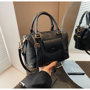 Detailed macro view of black vintage leather bag with gold hardware and snap button pocket
