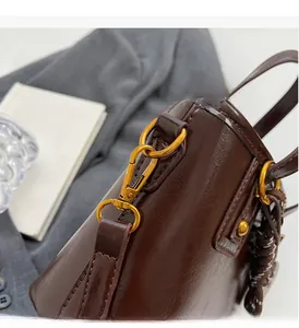 Detailed macro view of glossy dark brown leather bag with high-end gold hardware finish