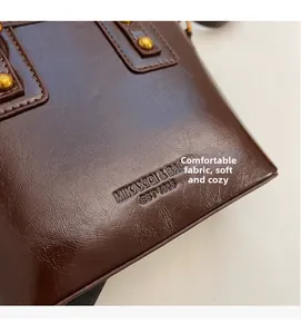 Close-up of retro bucket bag featuring litchi grain leather and gold rivet hardware