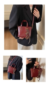 Three-view detail of a glossy wine red bucket bag with a decorative brown ring charm