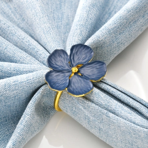 Classic blue flower napkin ring with gold petals edge and ring on a light blue napkin