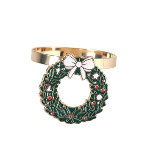Christmas wreath napkin ring with white bow and gold metal finish on white background