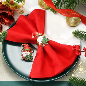 Santa Claus Christmas napkin ring with green tree and rhinestones on a festive plate
