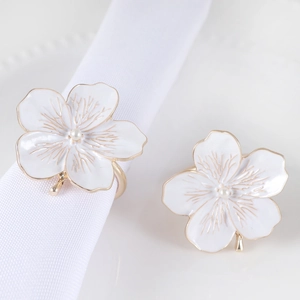 Close-up of plum blossom napkin ring with white enamel petals and pearl center detail