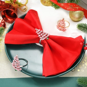 Serviettenring mit rosa Weihnachtsbaum und roten Schmucksteinen auf roter Serviette