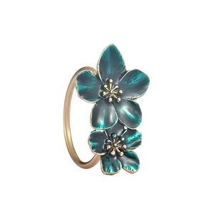 Primer plano del servilletero dorado con pétalos de flores en esmalte verde oscuro